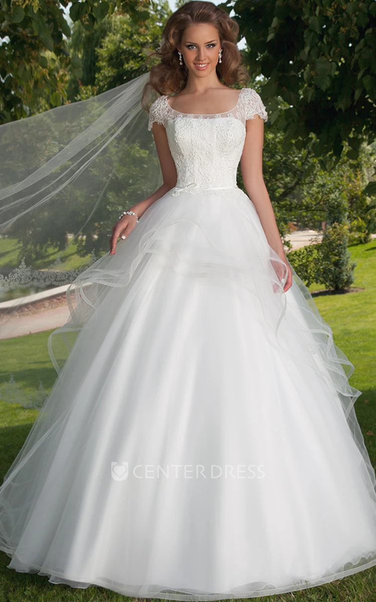 Cape sleeved wedding dress with illusion neckline and floral appliqué  across the bodice